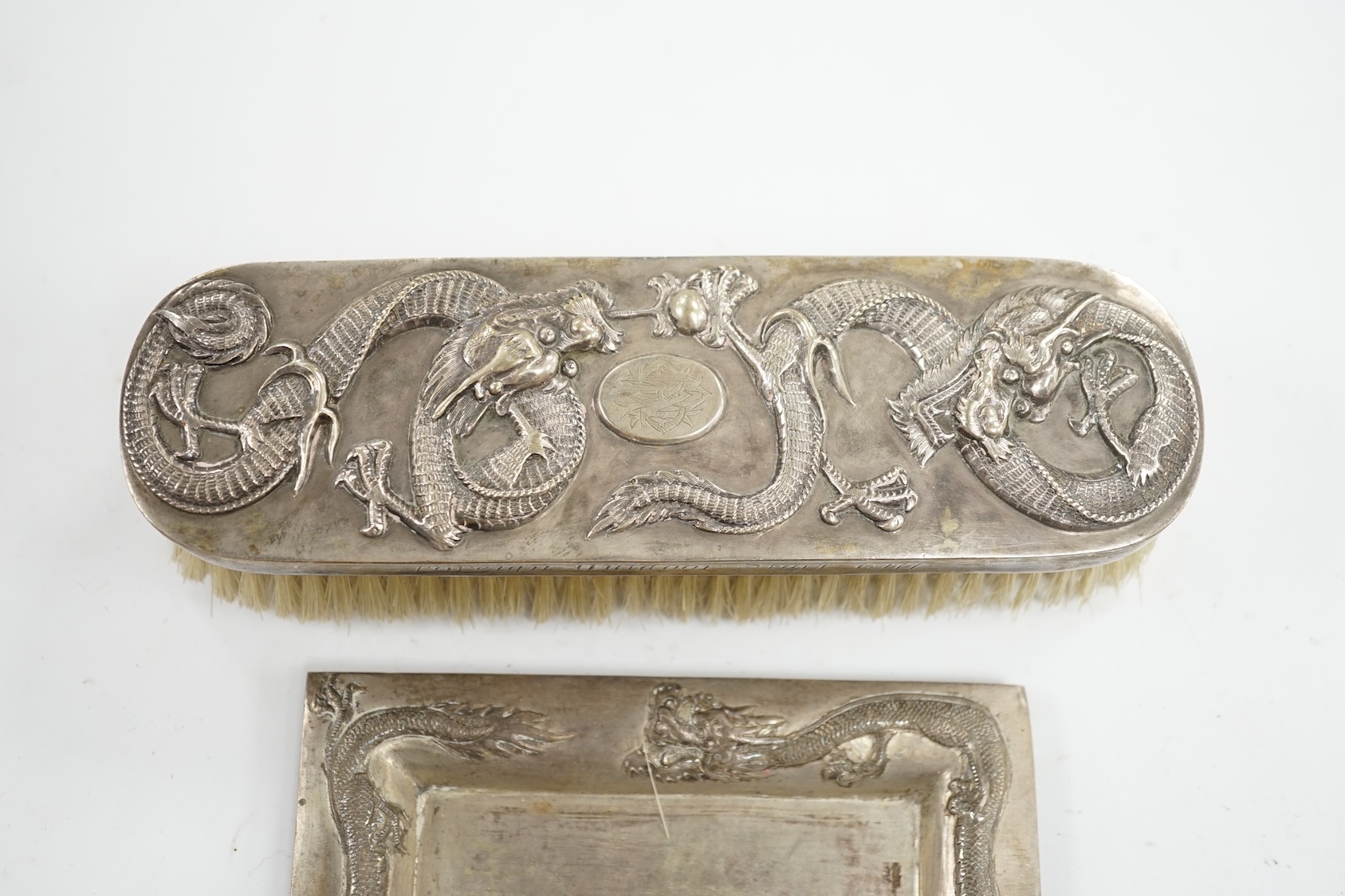 A Chinese white metal brush inscribed 'Presented by the Hokow Foreign Outdoor Staff 1911' and a similar small trinket dish. Condition - fair